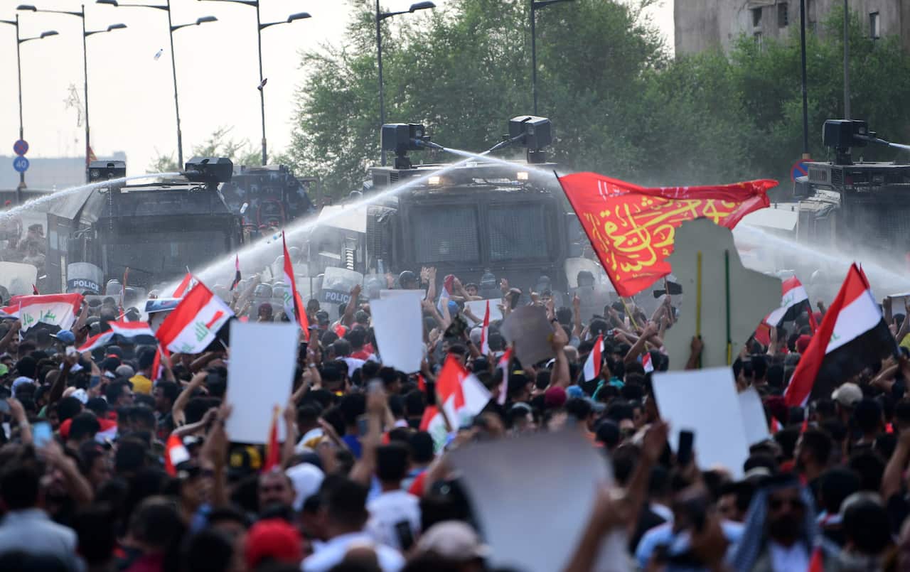 Iraqi anti-riot policemen use water cannons to block Iraqi protestors during a demonstration at al-Tahrir square in central Baghdad.