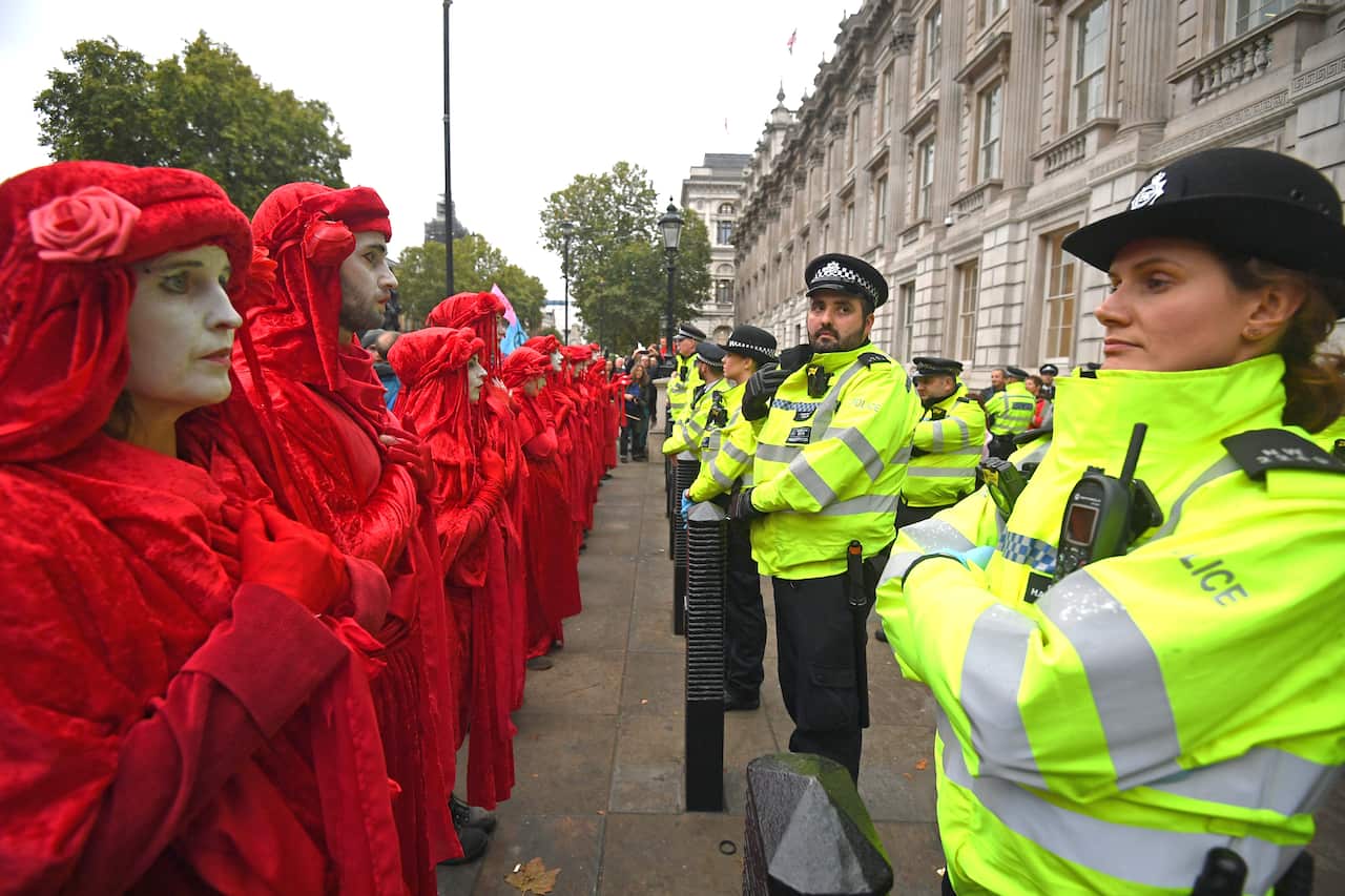 Protesters, dubbed the Red Rebels, outside the Cabinet Office on Whitehall, during an Extinction Rebellion (XR) protest in Westminster, London.