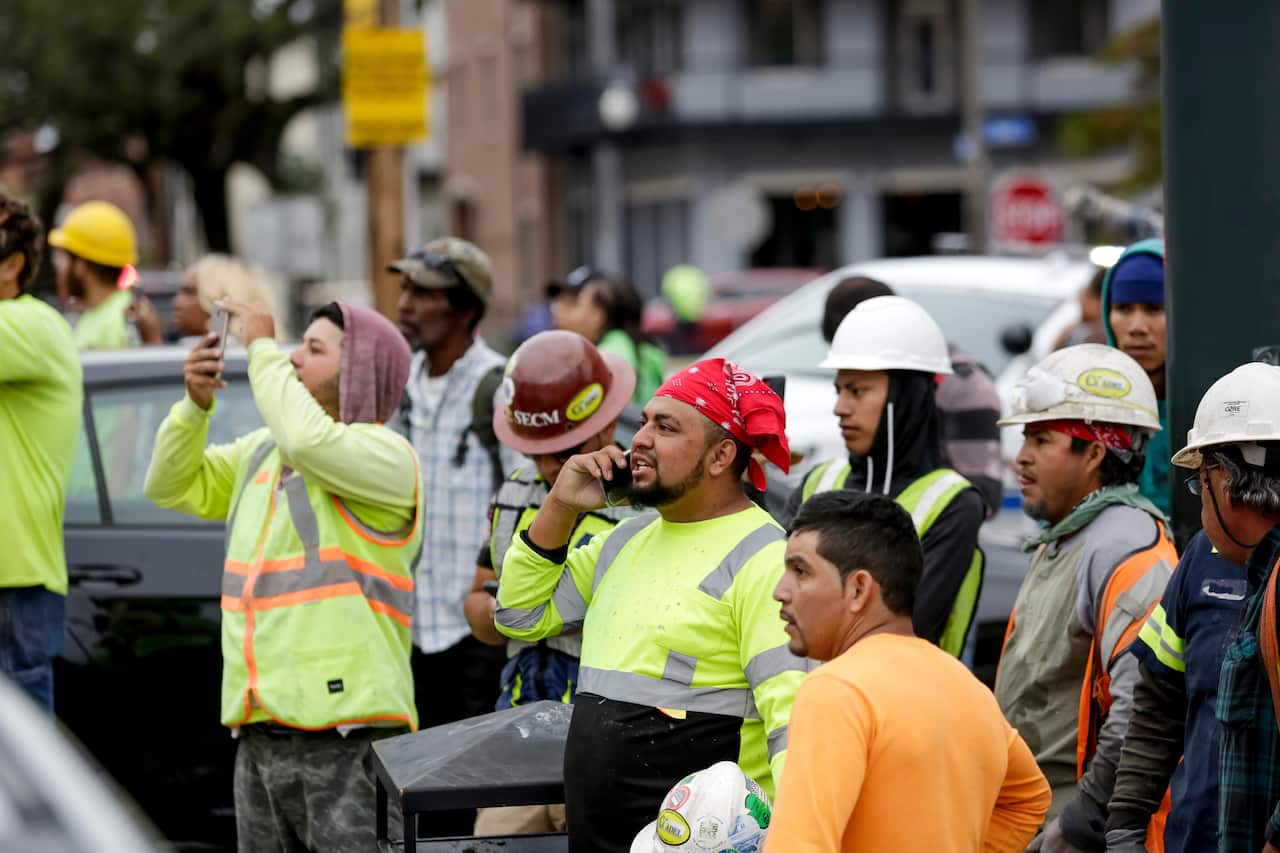 Workers assess the damage after a construction crane collapsed on the site.
