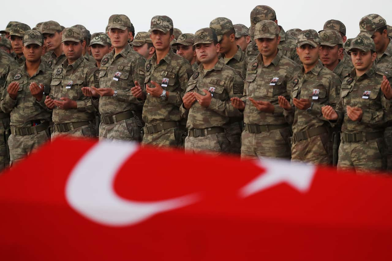 Turkish soldiers pray in front to the Turkish flag-draped coffin of soldier Sefa Findik killed in action with Kurdish fighters in Syria earlier Sunday.