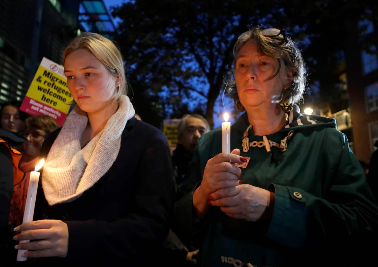 Demonstrators hold banners and candles during a vigil for the 39 lorry victims, outside the Home Office in London.