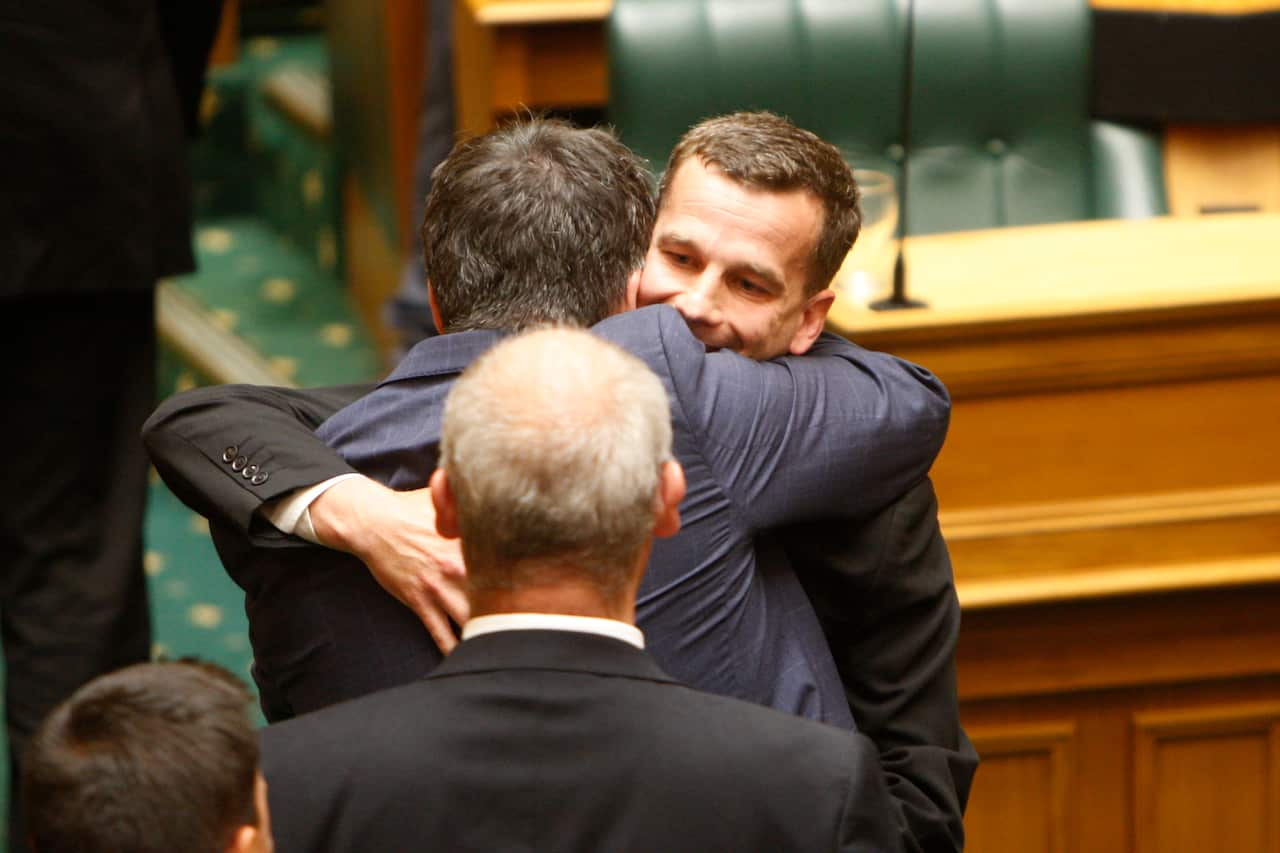 Euthanasia bill sponsor David Seymour (center) embraces other lawmakers in Parliament on Wednesday.