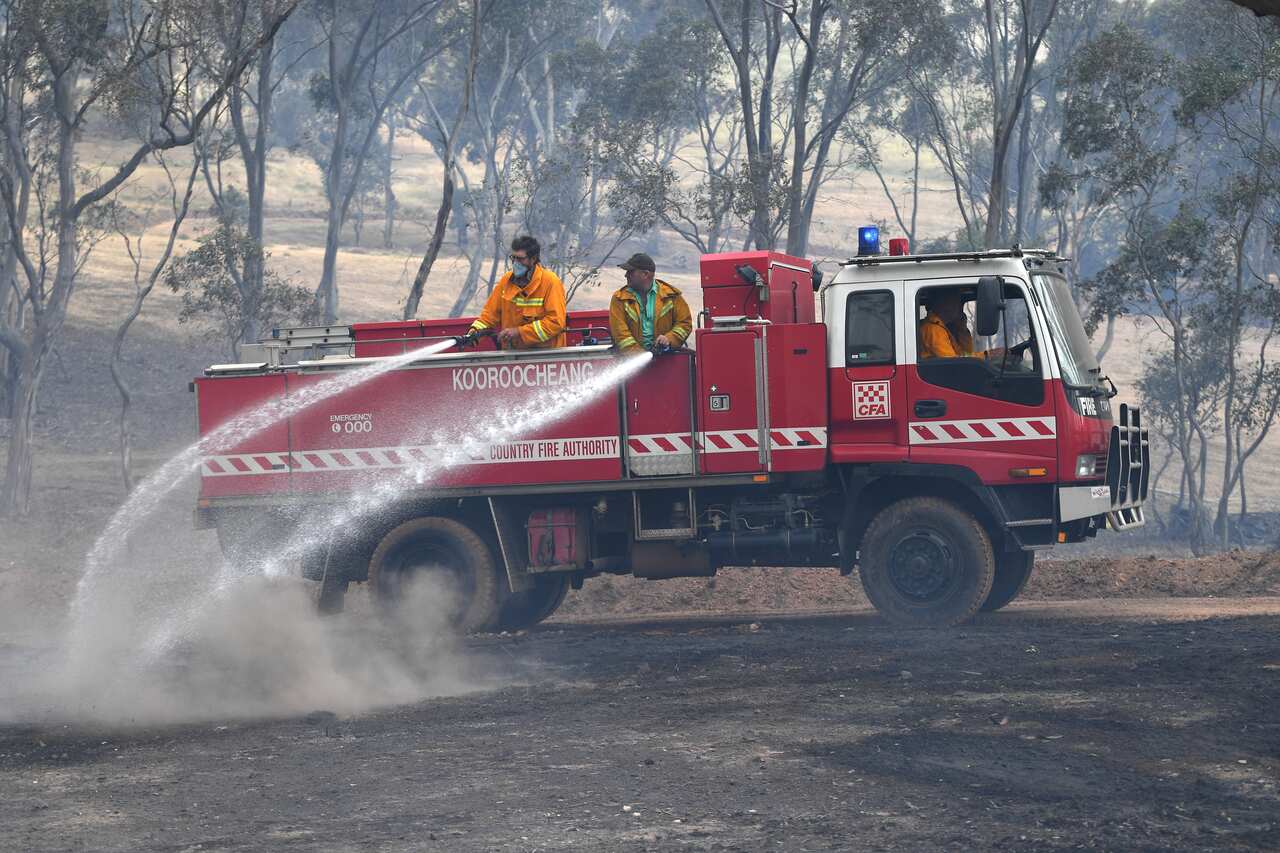 CFA firefighters are seen spraying water onto smouldering bushland at Mount Glasgow, Victoria.
