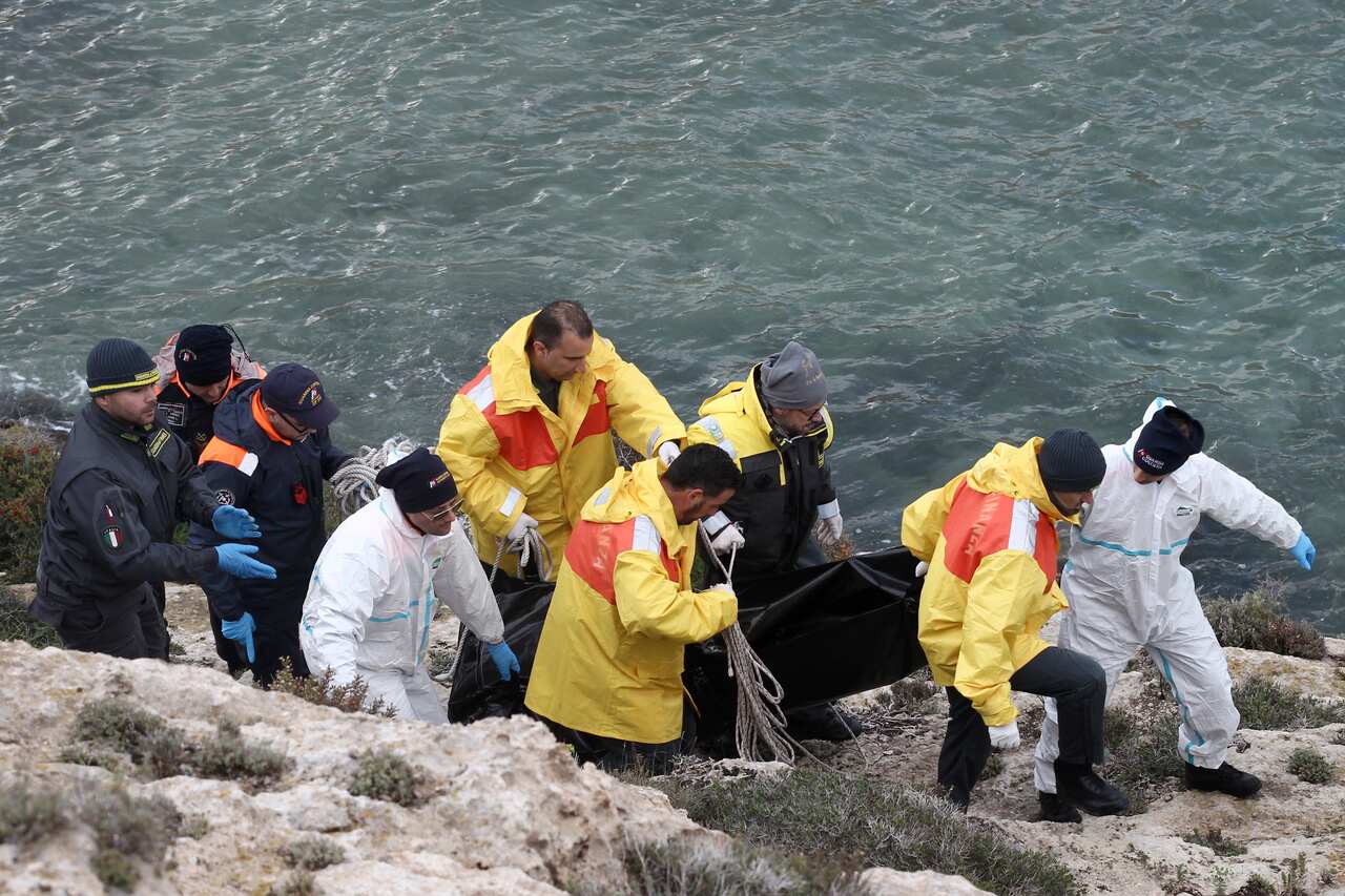 Rescuers carry a body recovered at sea near the Sicilian island of Lampedusa, southern Italy.