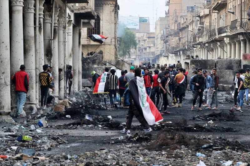Anti-government protesters gather while security forces close Rasheed Street, in Baghdad, Iraq, Sunday, Dec. 1, 2019.