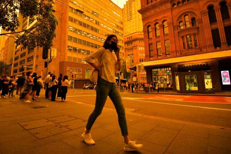 A woman wearing a mask is seen in the Sydney CBD as smoke haze blankets Sydney, 6 December 2019