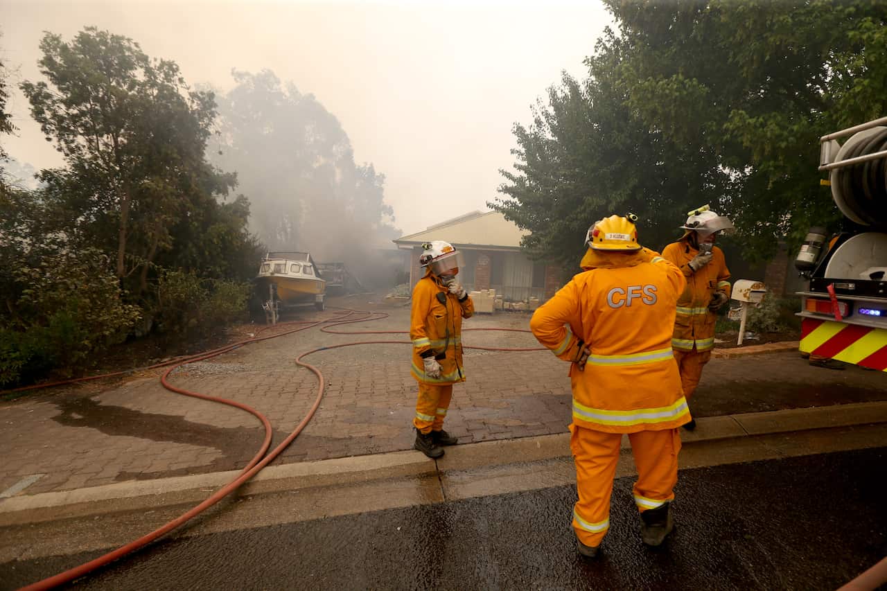 CFS firefighters put out fires on Jacaranda Drive at Woodside in the Adelaide Hills.