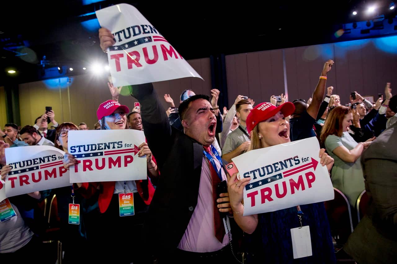 Members of the audience cheer as Donald Trump takes the stage at the Turning Point USA Student Action Summit.