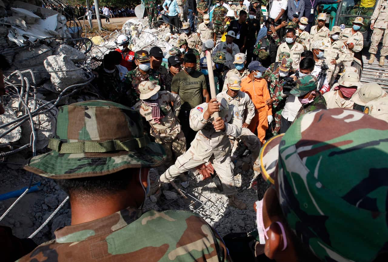Cambodian rescue worker swings a sledge hammer as they search for survivors of the building collapse.