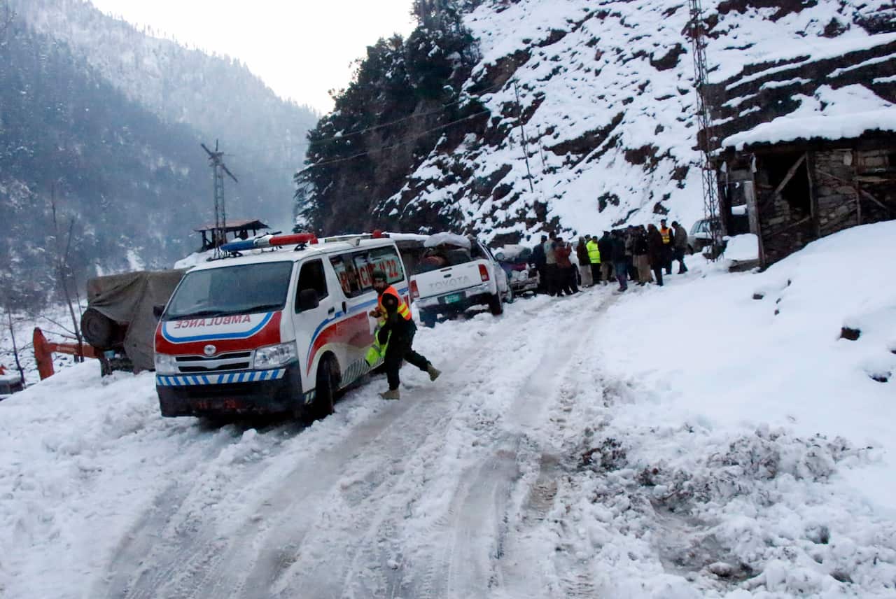 An ambulance, which heading to avalanches hit area, wait for road opening blocked by heavy snowfall, in Keran, in Neelum Valley.