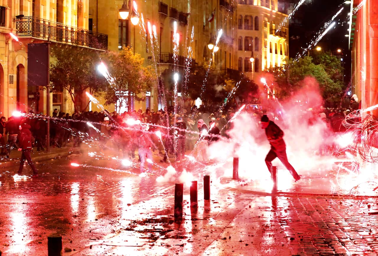 Anti-government protesters throw firecrackers at riot police during a protest against the new government.