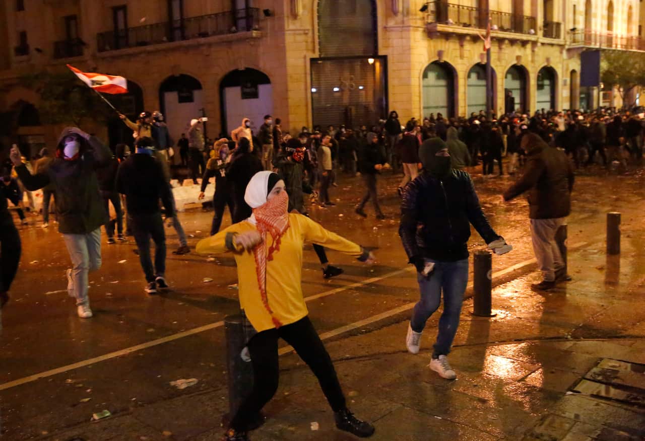 Anti-government protesters throw stones at riot police during a protest against the new government.