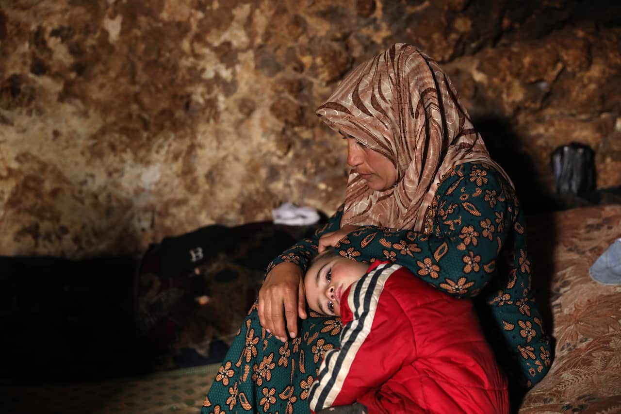 Displaced Syrians sit in an underground shelter in the Taltouna village, 17kms northwest of the city of Idlib, Syria.