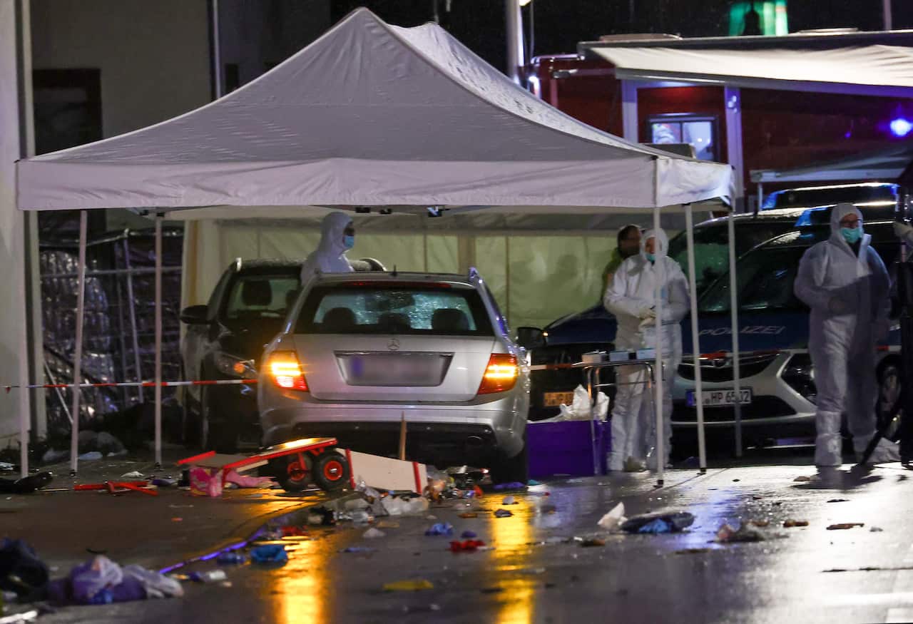 Forensic experts investigate next to a silver Mercedes that crashed into a group of revelers during the Rose Monday carnival parade in Volkmarsen.