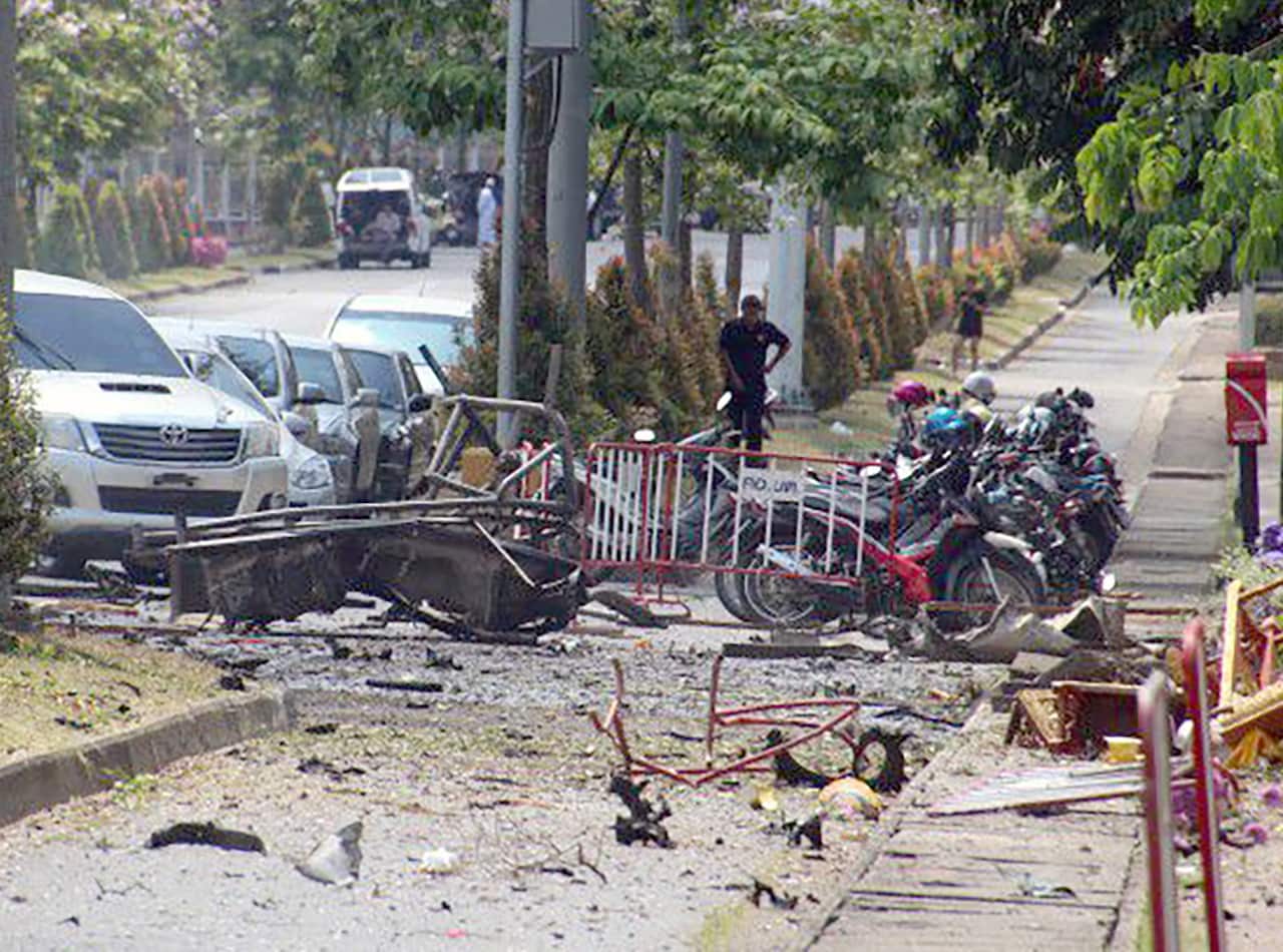 A destroyed vehicle sits on a road after a car bomb attack during official meeting about the spread of COVID-19.