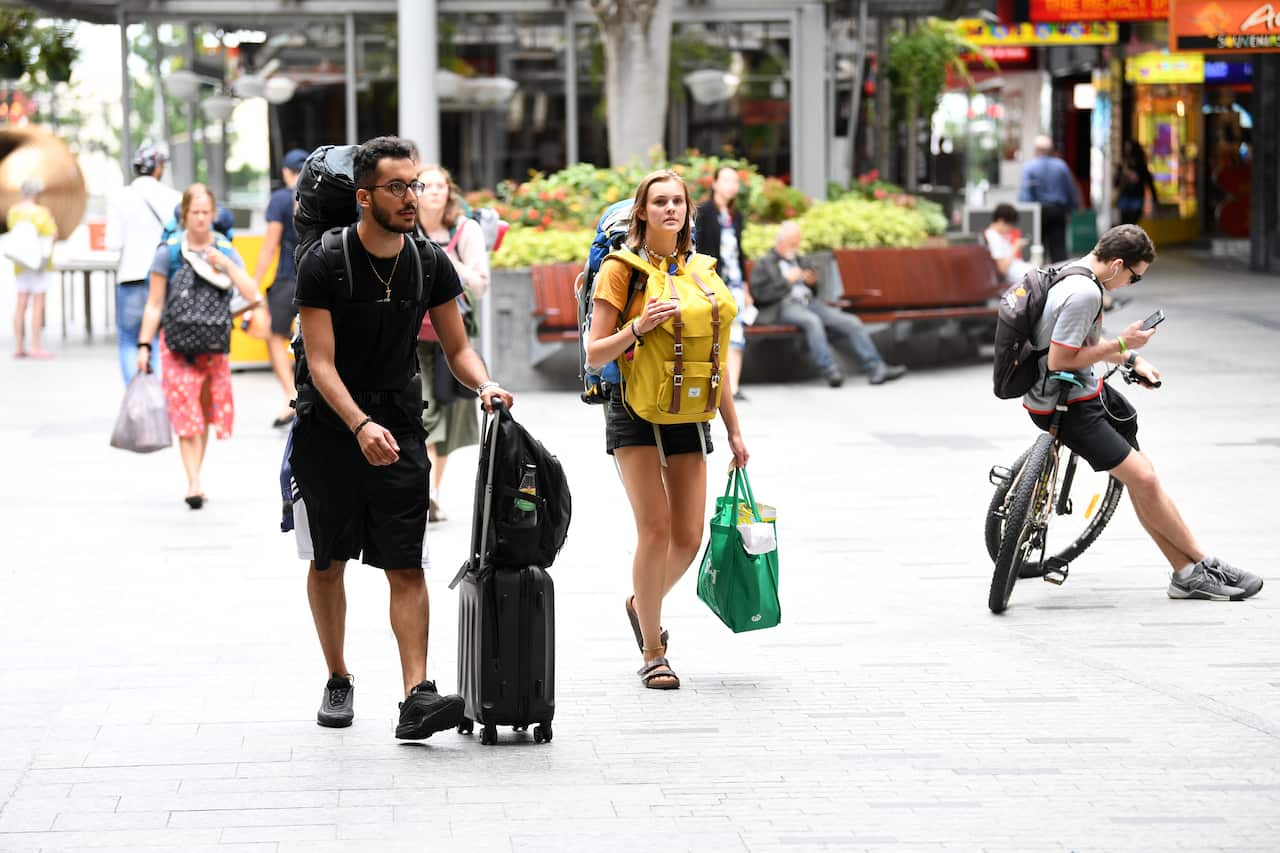 Backpackers are seen in central Brisbane, Tuesday, March 24, 2020.