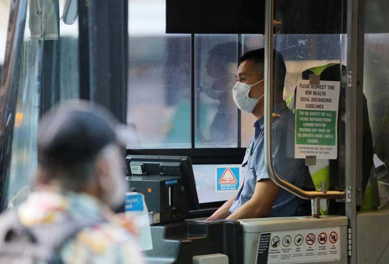 A bus driver wears a mask as a preventative measure against COVID-19 at Railway Square bus station in Sydney.