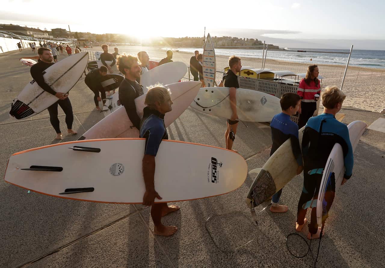 Surfers wait for officials to open Bondi Beach.