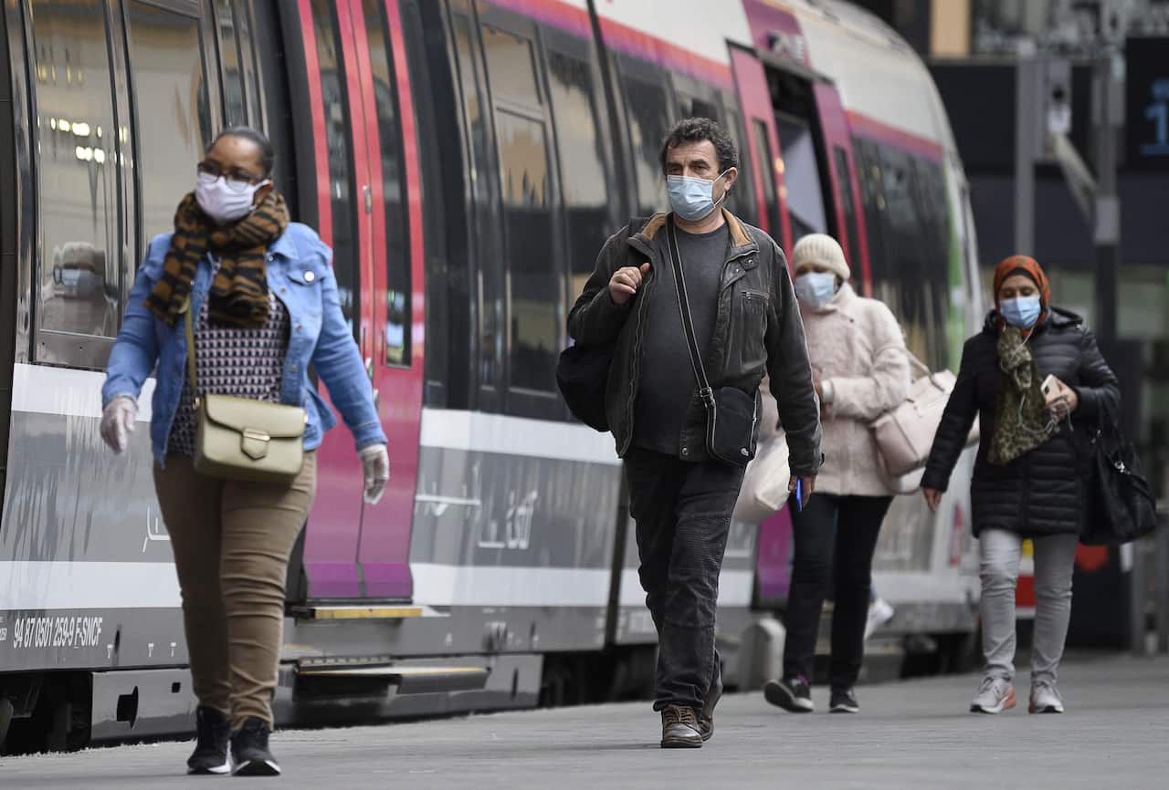 People wearing a protective mask and alternative mask arrive at the train station Gare Saint Lazare in Paris, France, 28 April 2020.