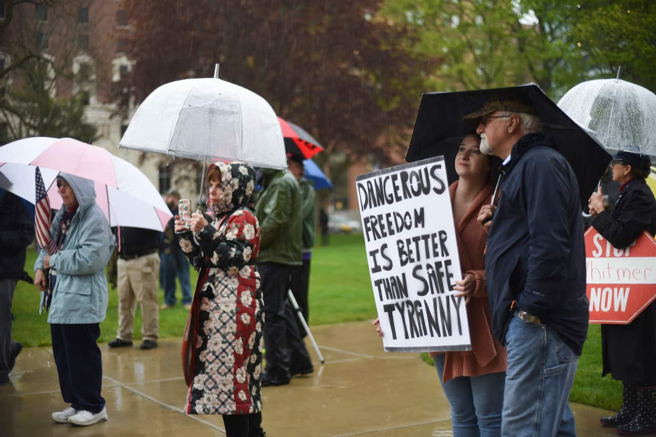 Protesters brave the rain to protest Michigan Gov. Gretchen Whitmer's stay-at-home order at the Michigan State Capitol in Lansing.