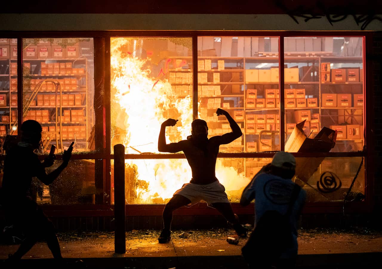 A fire burns at an AutoZone store in Minneapolis as people riot over the death of George Floyd.