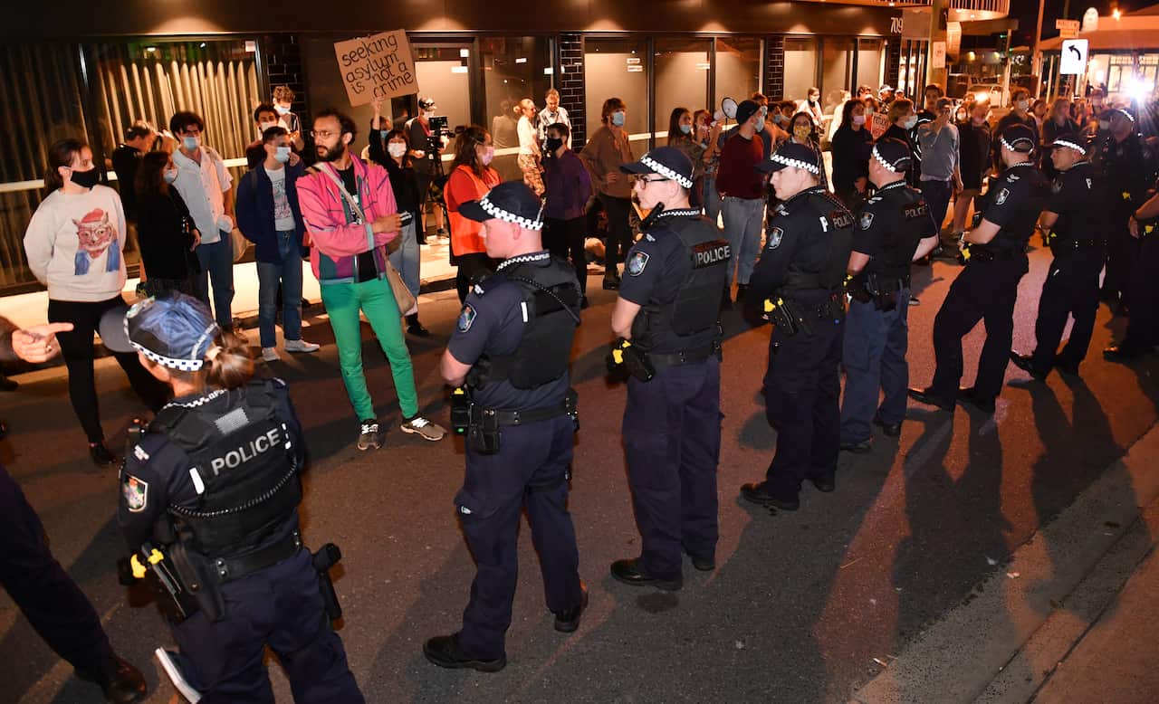 Police and protestors are seen outside the Kangaroo Point Central Hotel in Brisbane, Friday 12 June.
