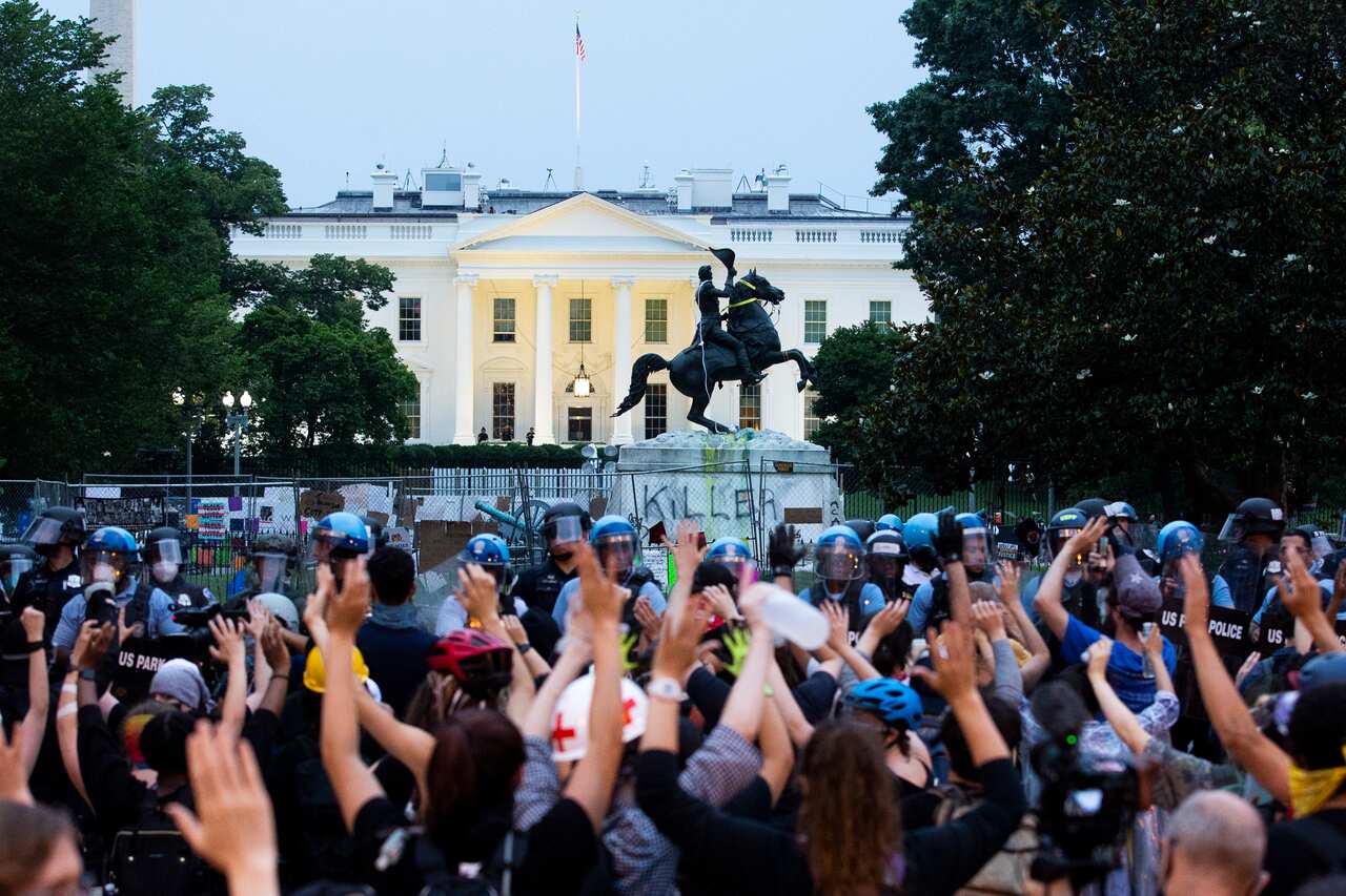 Protesters put their hands in the air after attempting to pull down the Andrew Jackson statue.
