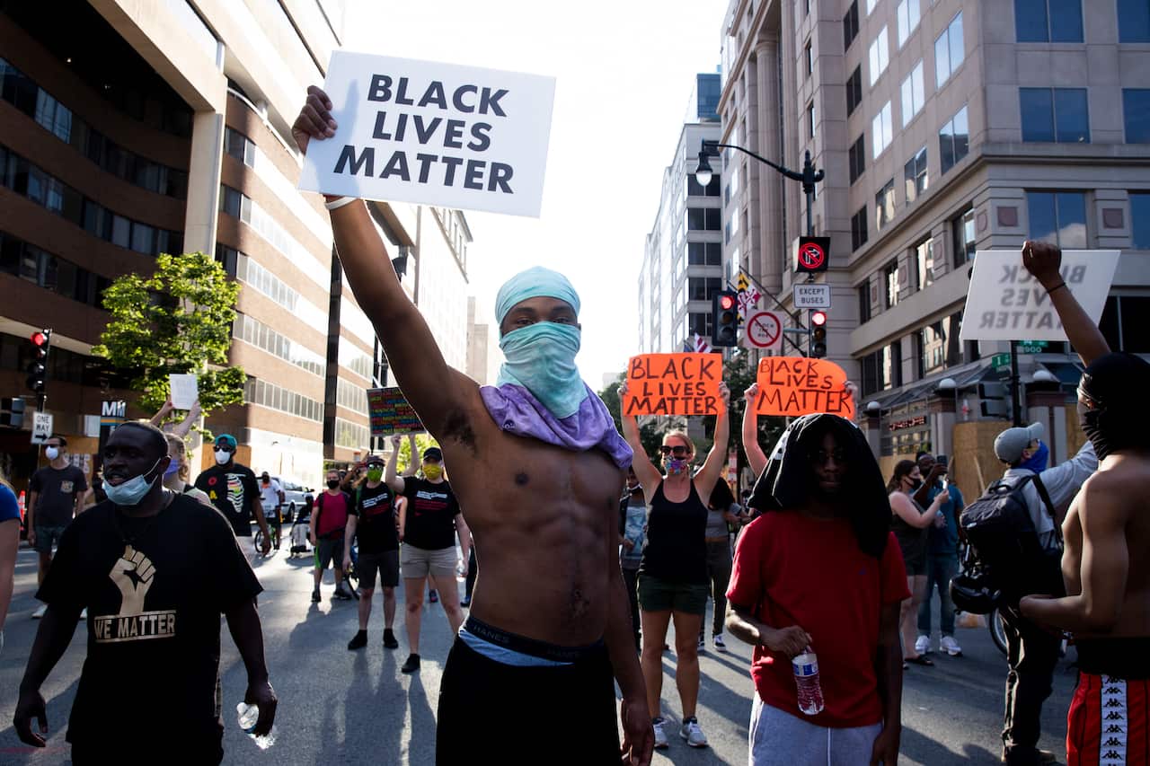 Black Lives Matter (BLM) supporters hold placards while marching in Washington DC, USA, 24 June 2020. 