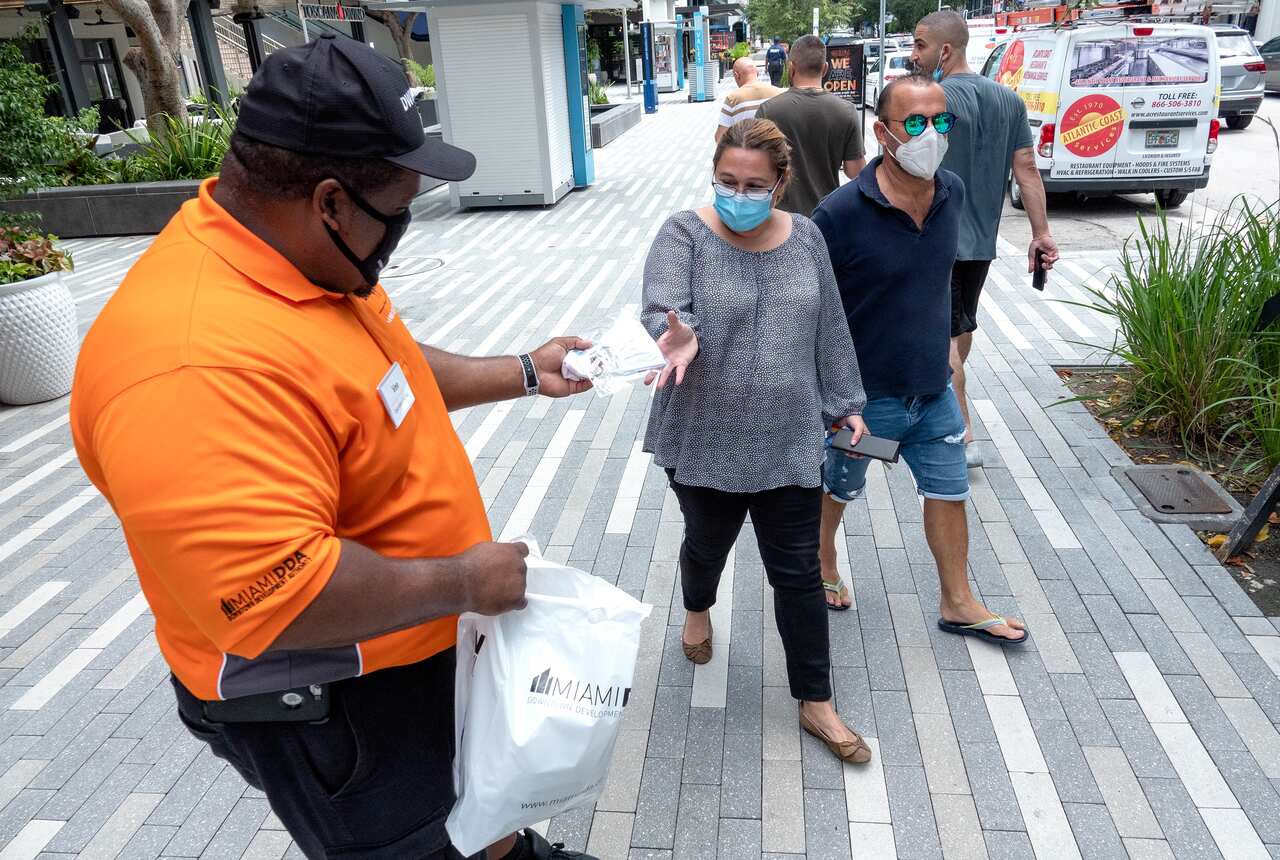 An health worker distributes free face masks in Downtown Miami, Florida.