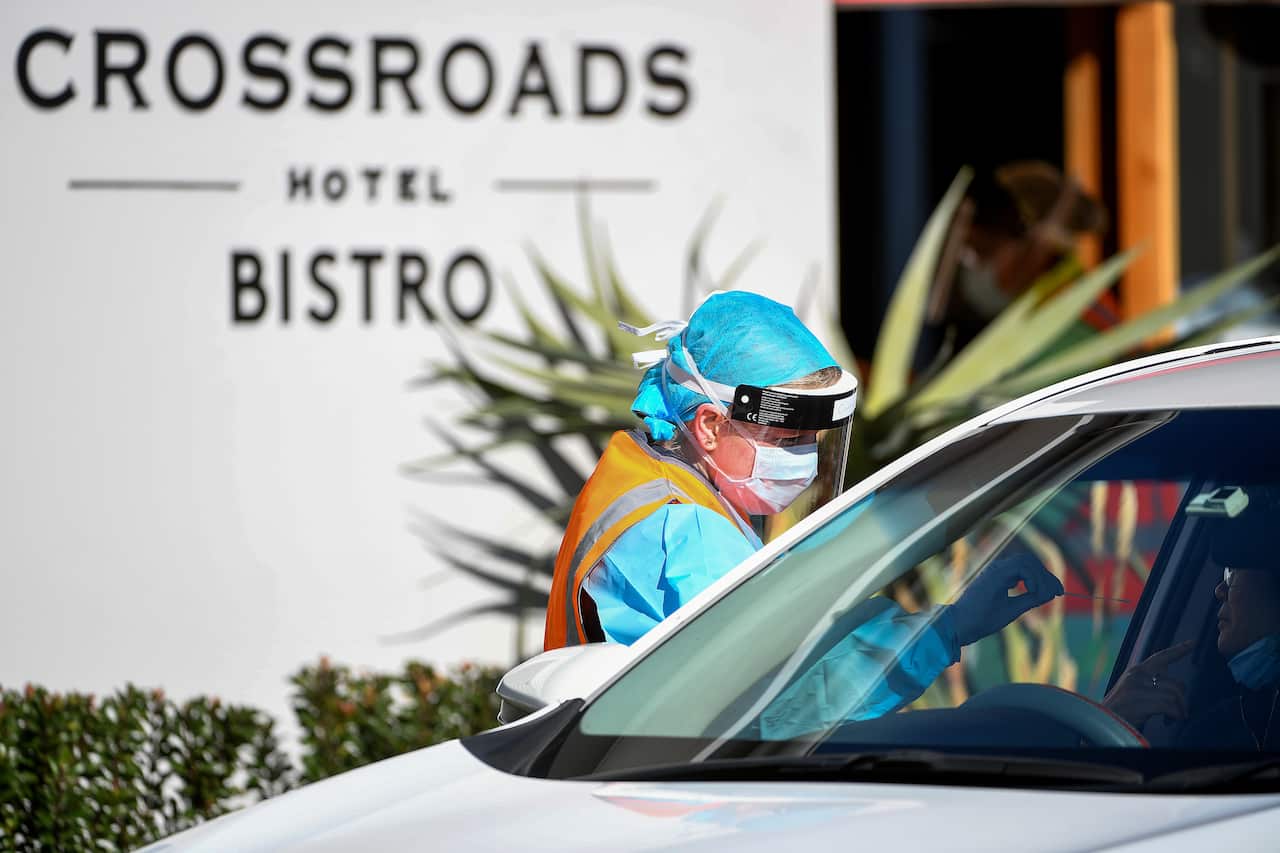 NSW Health workers administering COVID-19 tests to people in their cars at the Crossroads Hotel testing centre in Sydney.