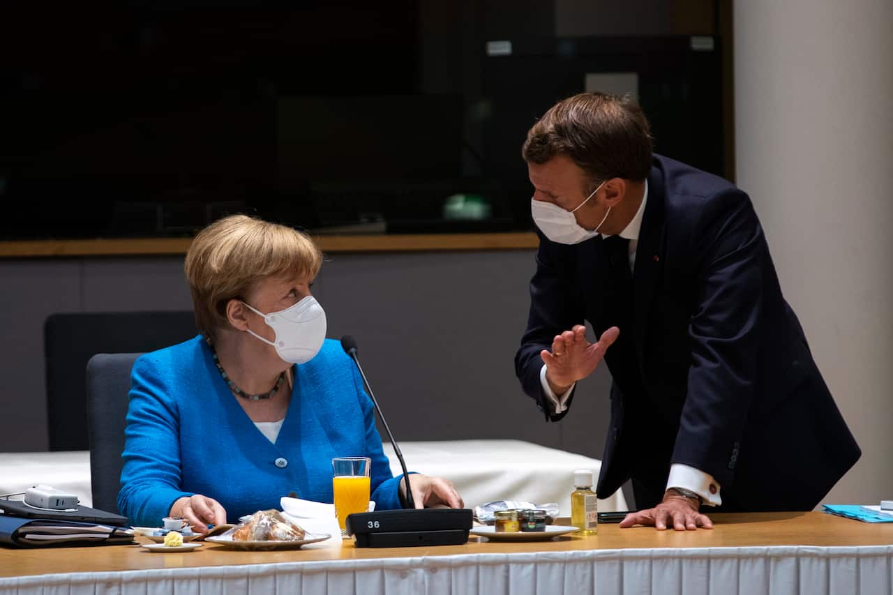 German Chancellor Angela Merkel speaks with French President Emmanuel Macron during a meeting on the sidelines of an EU summit in Brussels.