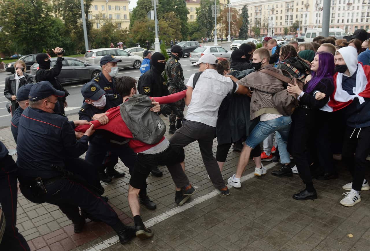 Belarus police and OMON officers detain students who march with opposition flags to show their solidarity with political prisoners.