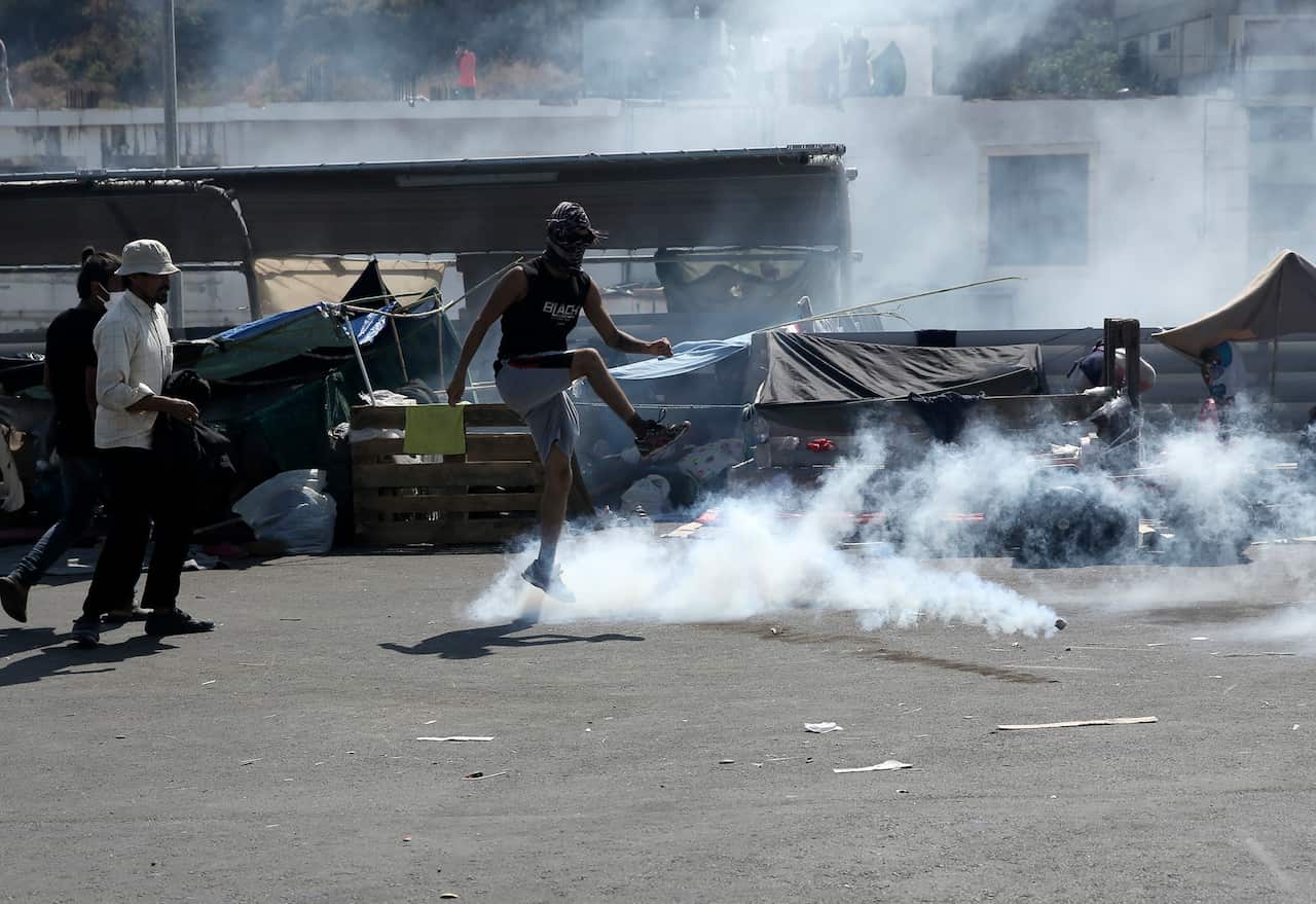A man kicks a tear gas canister during minor clashes between riot police and migrants near Mytilene town, on the northeastern island of Lesbos, Greece.