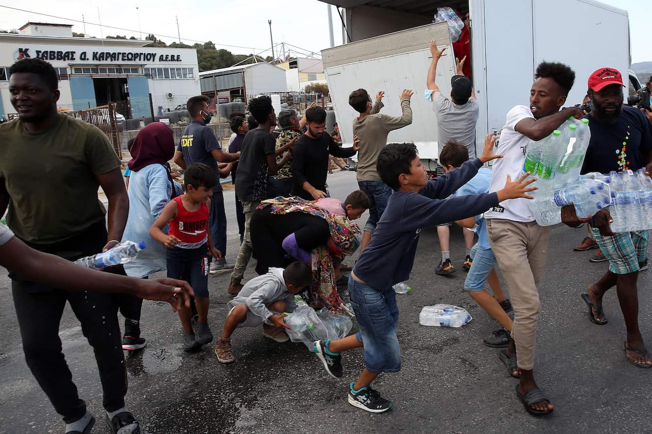 Asylum seekers scuffle to get some water near the new camp at Kara Tepe on Lesbos island, Greece, on 12 September.