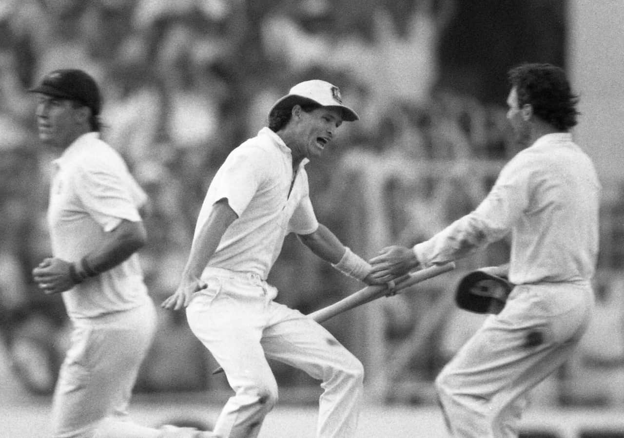 Australian batsman Dean Jones holds the stumps as he races to embrace team captain Allan Border, after Australia won the 1987 Cricket World Cup.