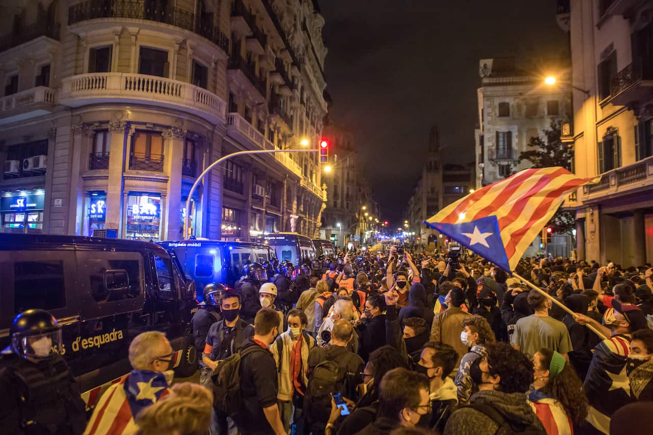 A demonstrator holds a Catalan independence flag.