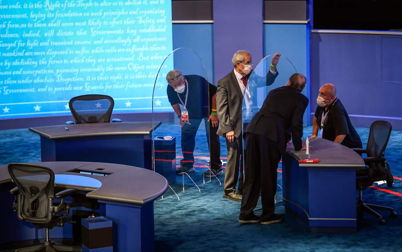 The plexiglass gets a final inspection and polish during preparations for the VP debate.