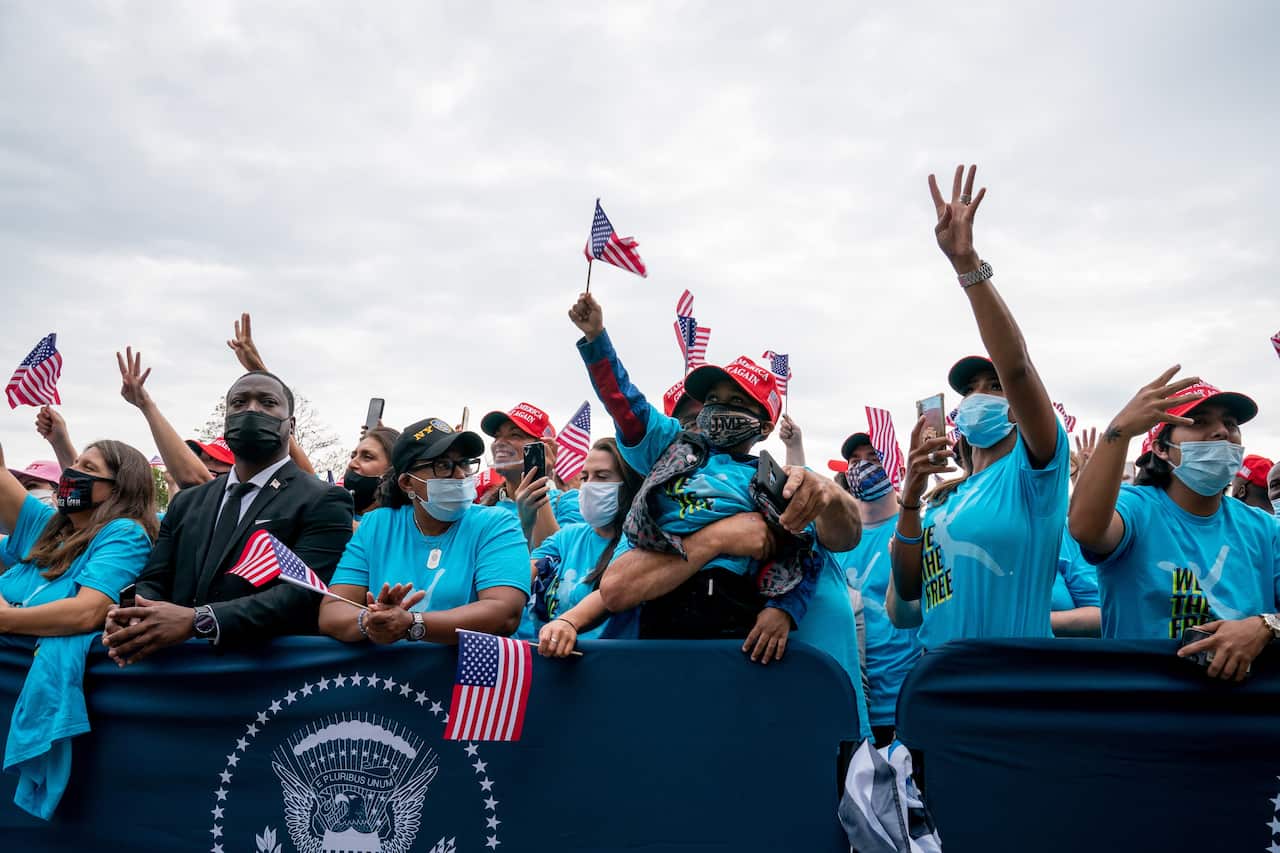 Supporters of US President Donald Trump react as he speaks from the Truman Balcony of the White House on 10 October, 2020.