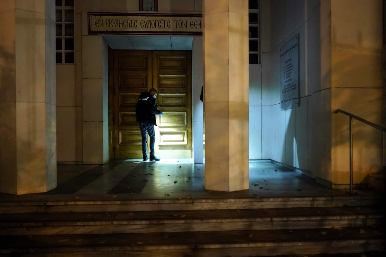 A police officer searches for clues after a priest was shot, Saturday Oct. 31, 2020, in the city of Lyon, central France.