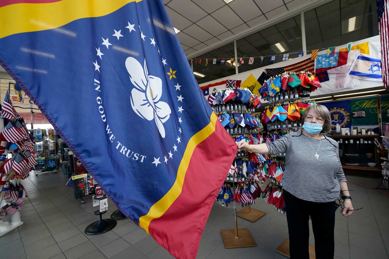 Brenda McIntyre, a co-owner of A Complete Flag Source store in Jackson, Mississippi shows off the magnolia-centered banner.