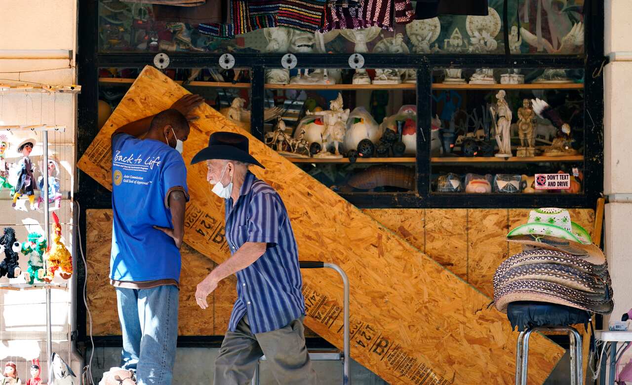 Workers board up windows at a business near the Alamo in downtown San Antonio, Texas.