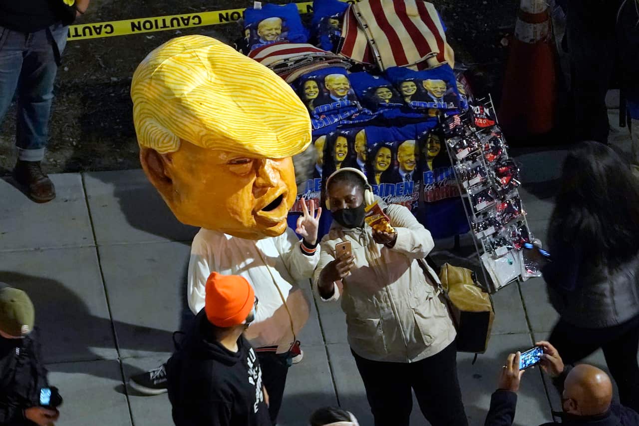 A person in a Donald Trump costume joins the protesters.