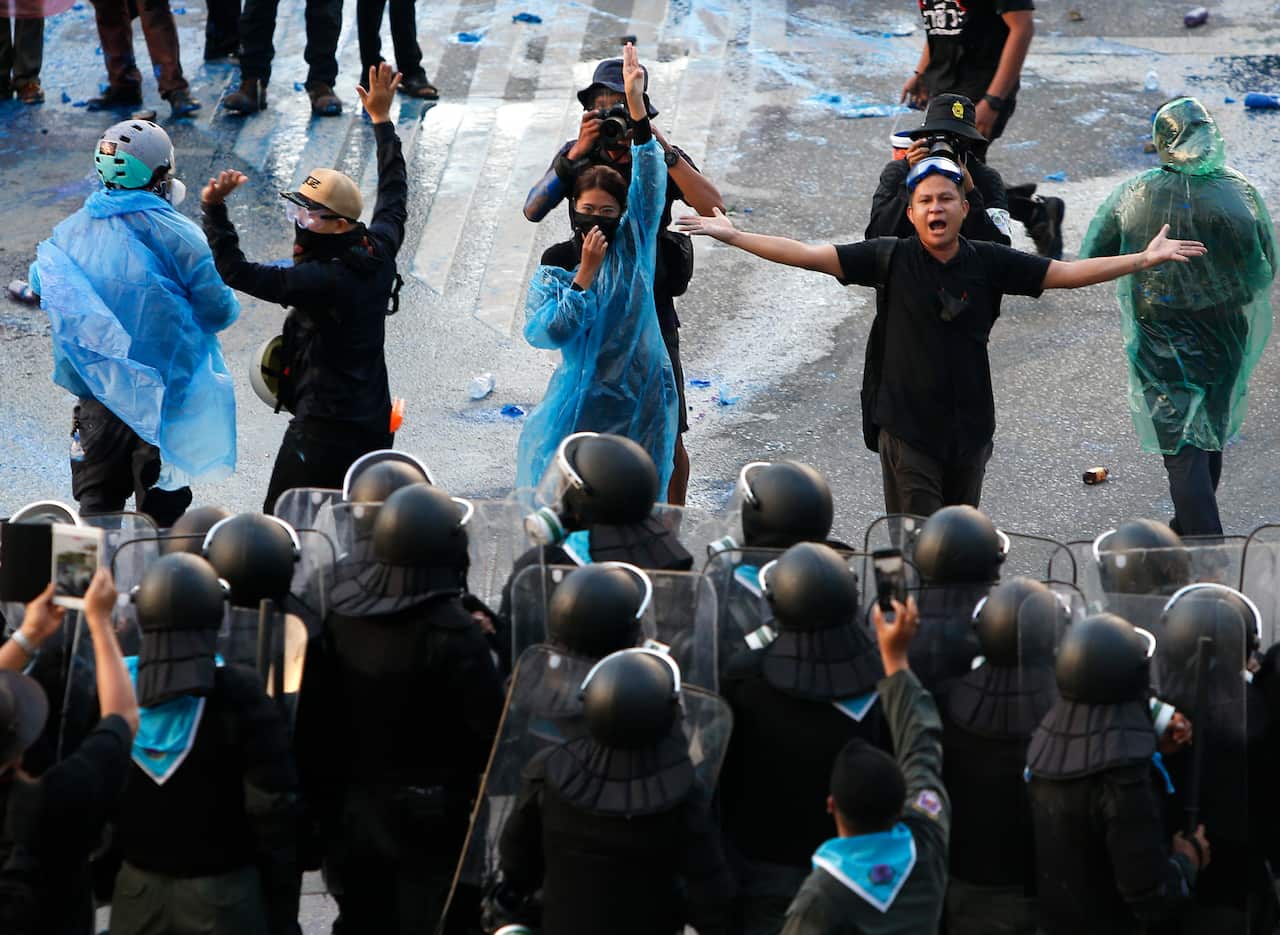 Pro-democracy protesters fight with riot-policemen during a rally near the Parliament in Bangkok, Thailand