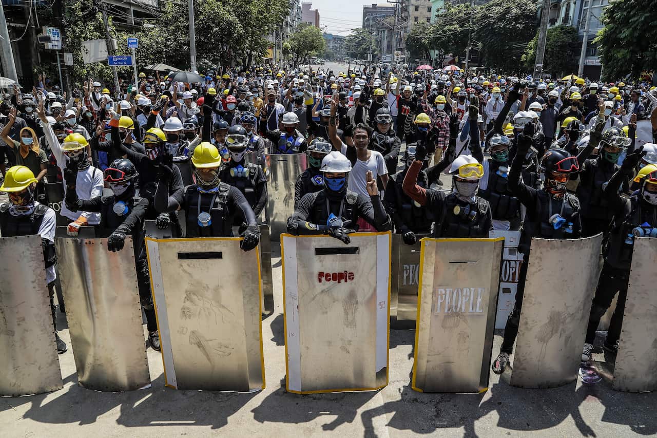 Demonstrators flash the three-finger salute during a protest in Yangon, Myanmar, 8 March 2021.