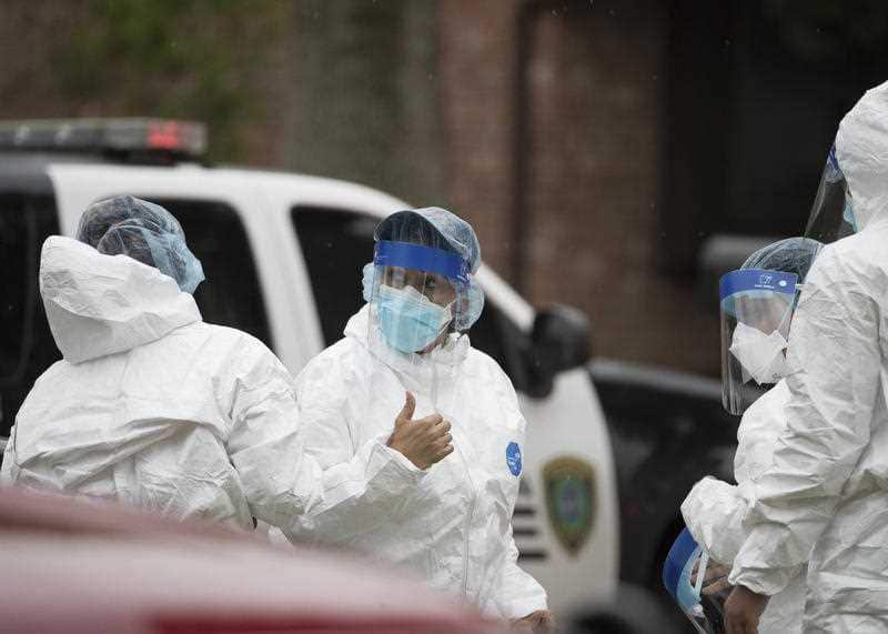 People wearing PPE at the Houston house where more than 90 undocumented immigrants were found inside