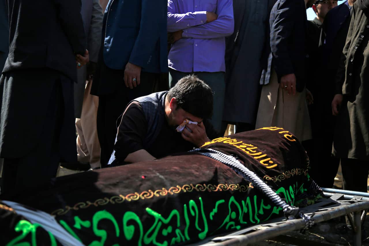 An Afghan man crying over the victim of deadly bombings on Saturday near a school west of Kabul, Afghanistan, Sunday, 9 May, 2021.