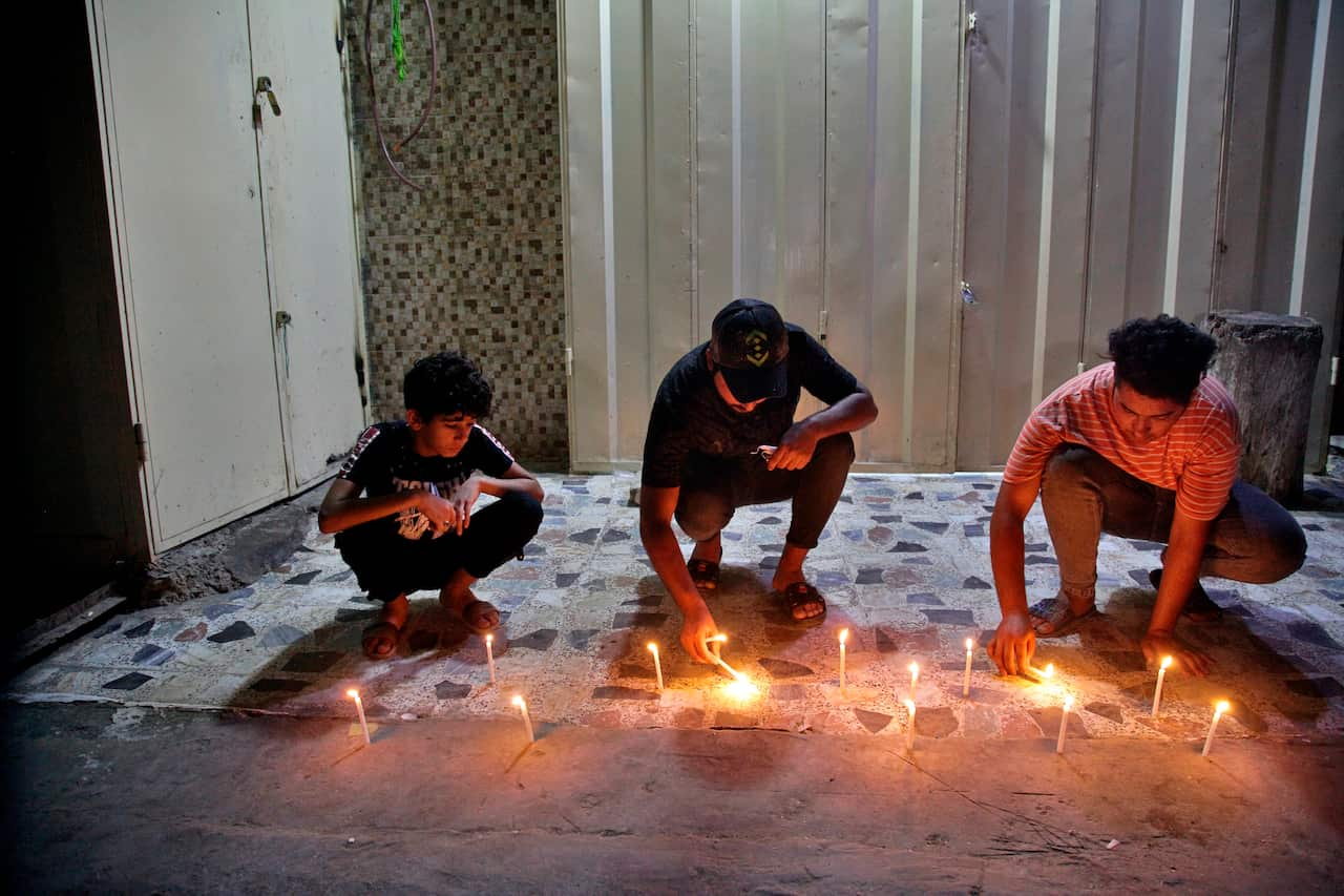 People light candles at the site of a bombing in Wahailat market in Sadr City, Iraq, Monday, 19 July, 2021.