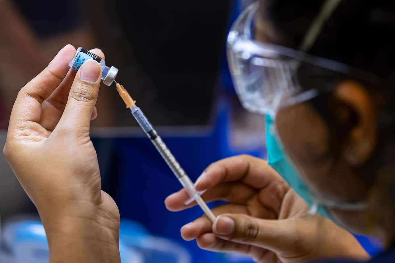 A health care worker prepares a Pfizer vaccine in the pharmacy of the Heidelberg Repatriation Hospital vaccination hub in Melbourne