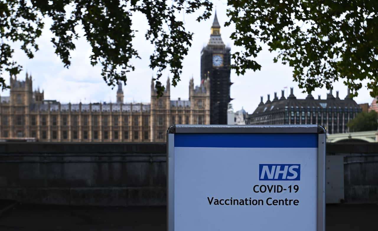 A sign outside a COVID-19 vaccination centre opposite parliament in London