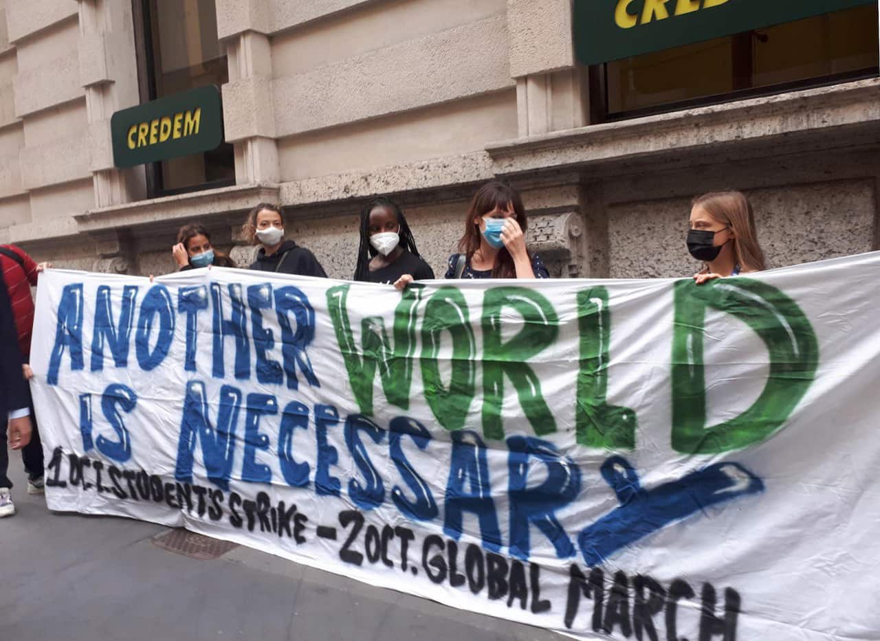 Young climate activists, hold up a large banner reading "Another World is Necessary" in front of the Prefecture in Milan, northern Italy.
